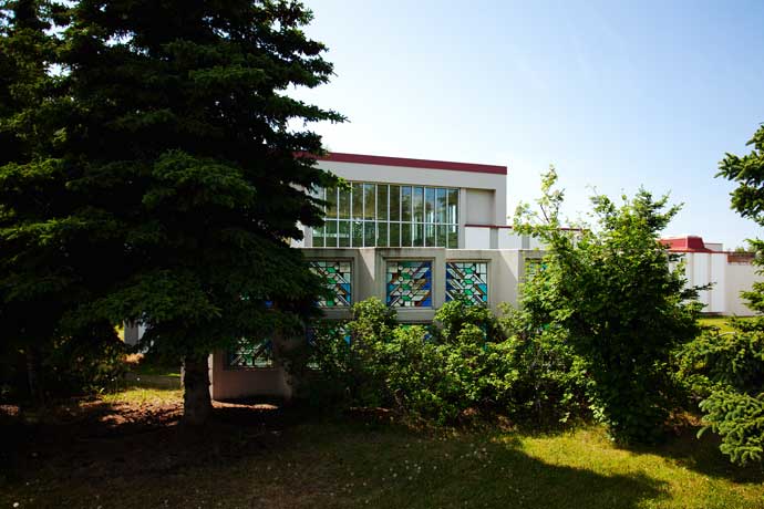 McLaughlin Youth Center exterior half hidden by trees.