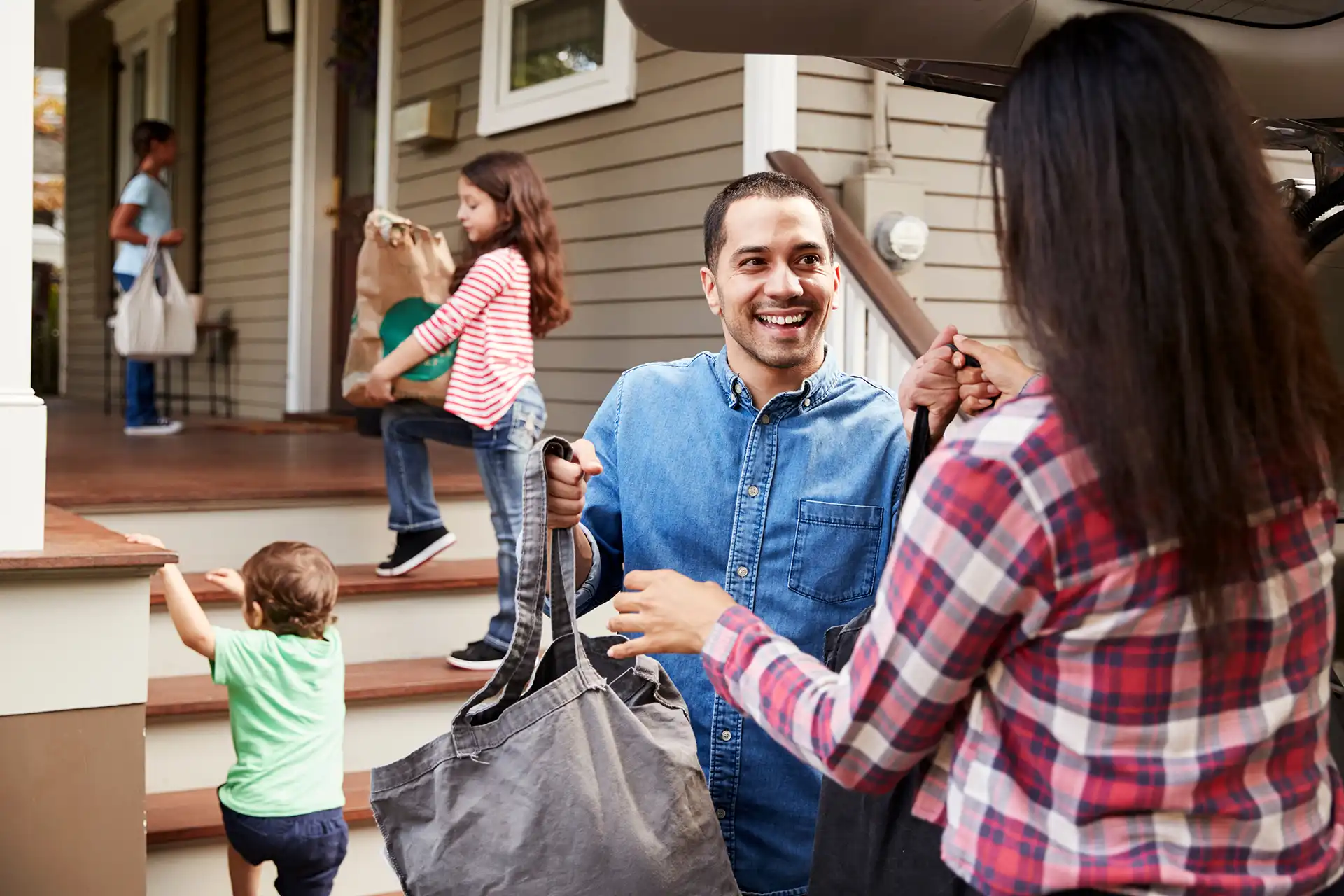 Family Unloading Shopping Bags From Car