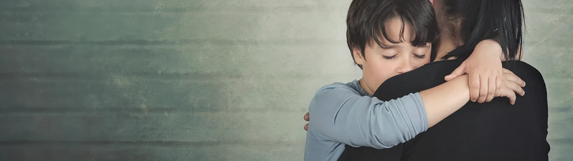Child hugging woman with relief or sadness