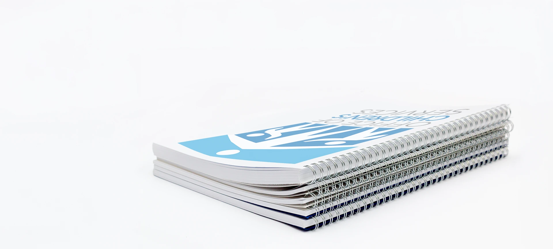 Stack of spiral-bound publications with OCS logo on top