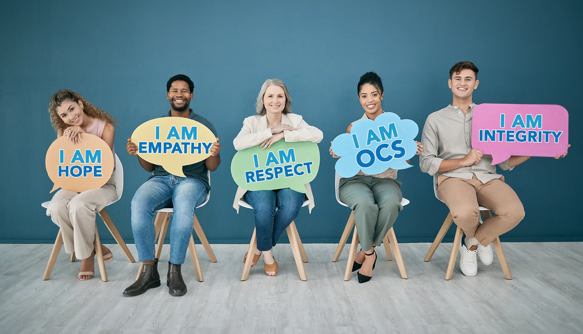 Five people holding signs saying: I am hope, I am empathy, I am respect, I am OCS, and I am integrity.