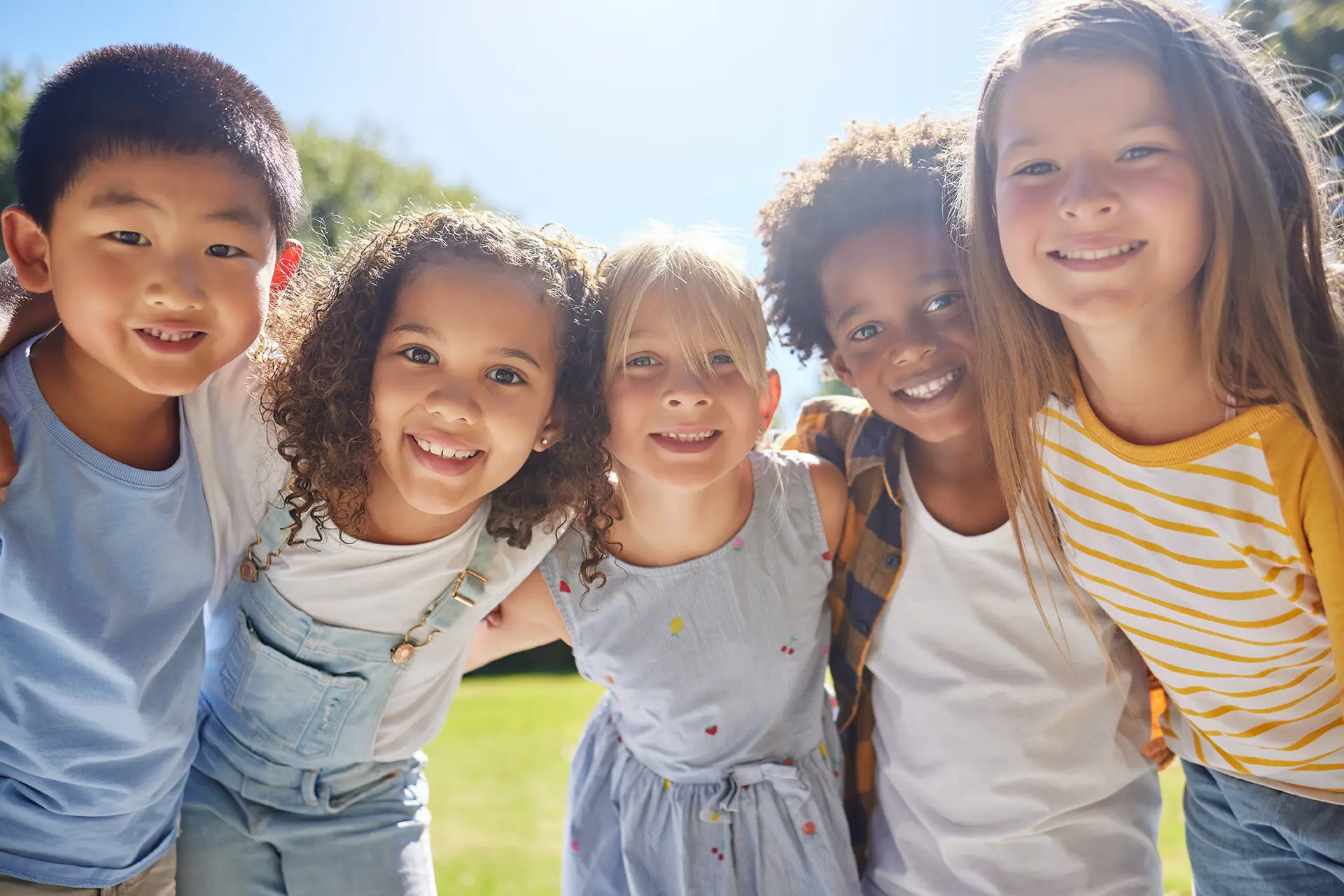 Five children posing arm-in-arm