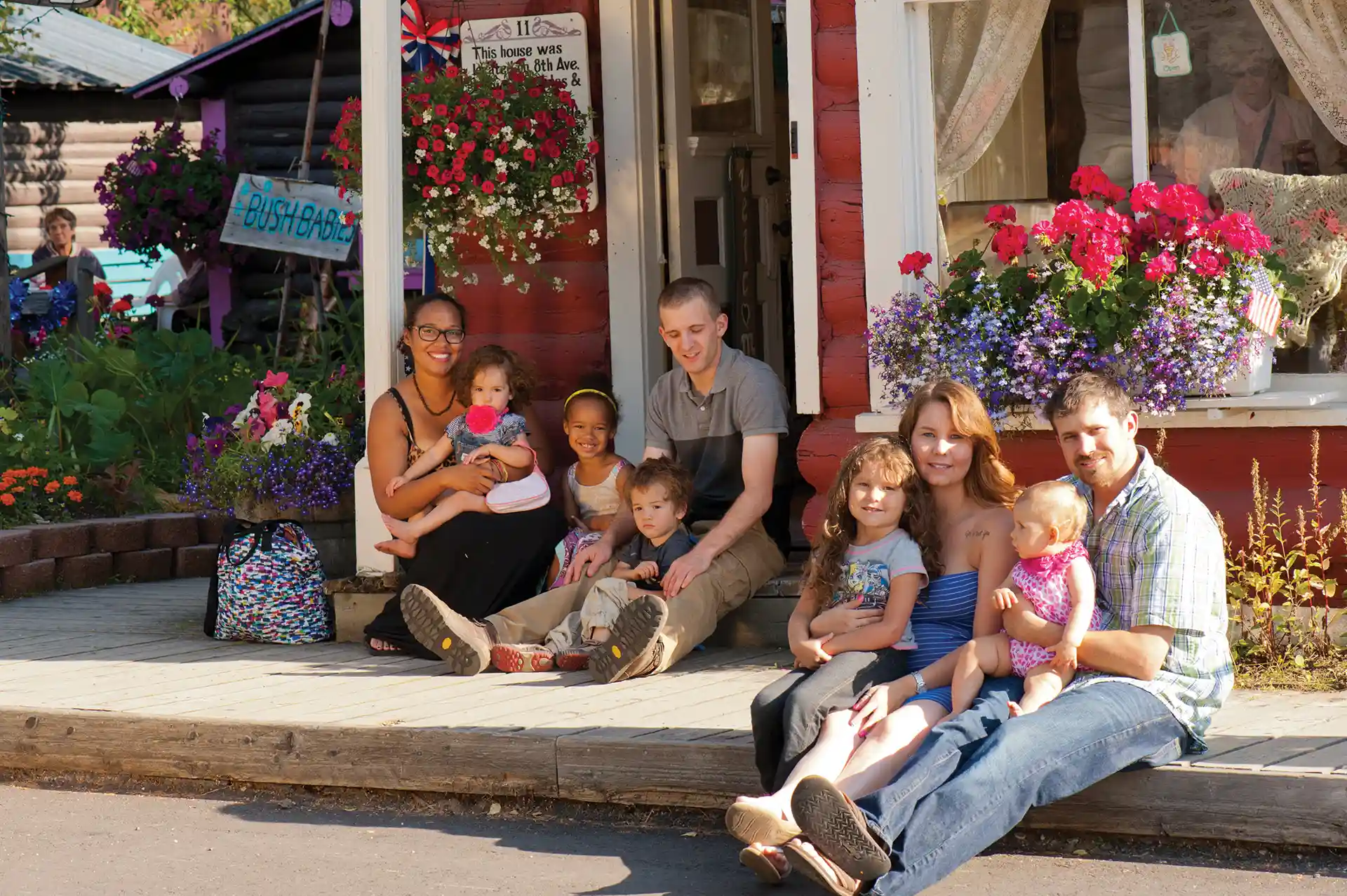 Two families sitting on the curb at the Fairbanks Fair