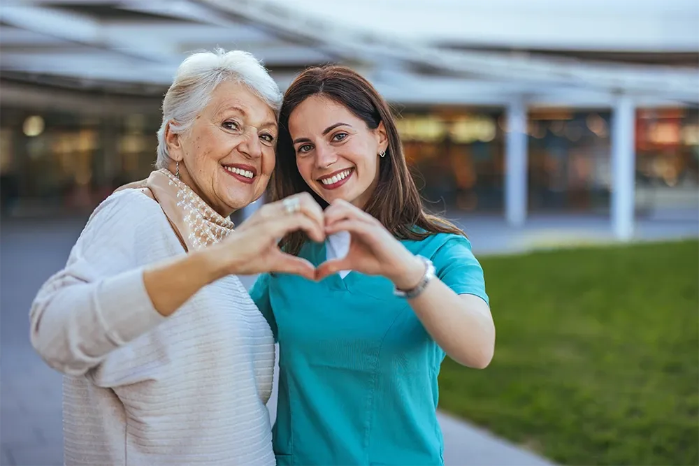 Two woman making a heart with their hands
