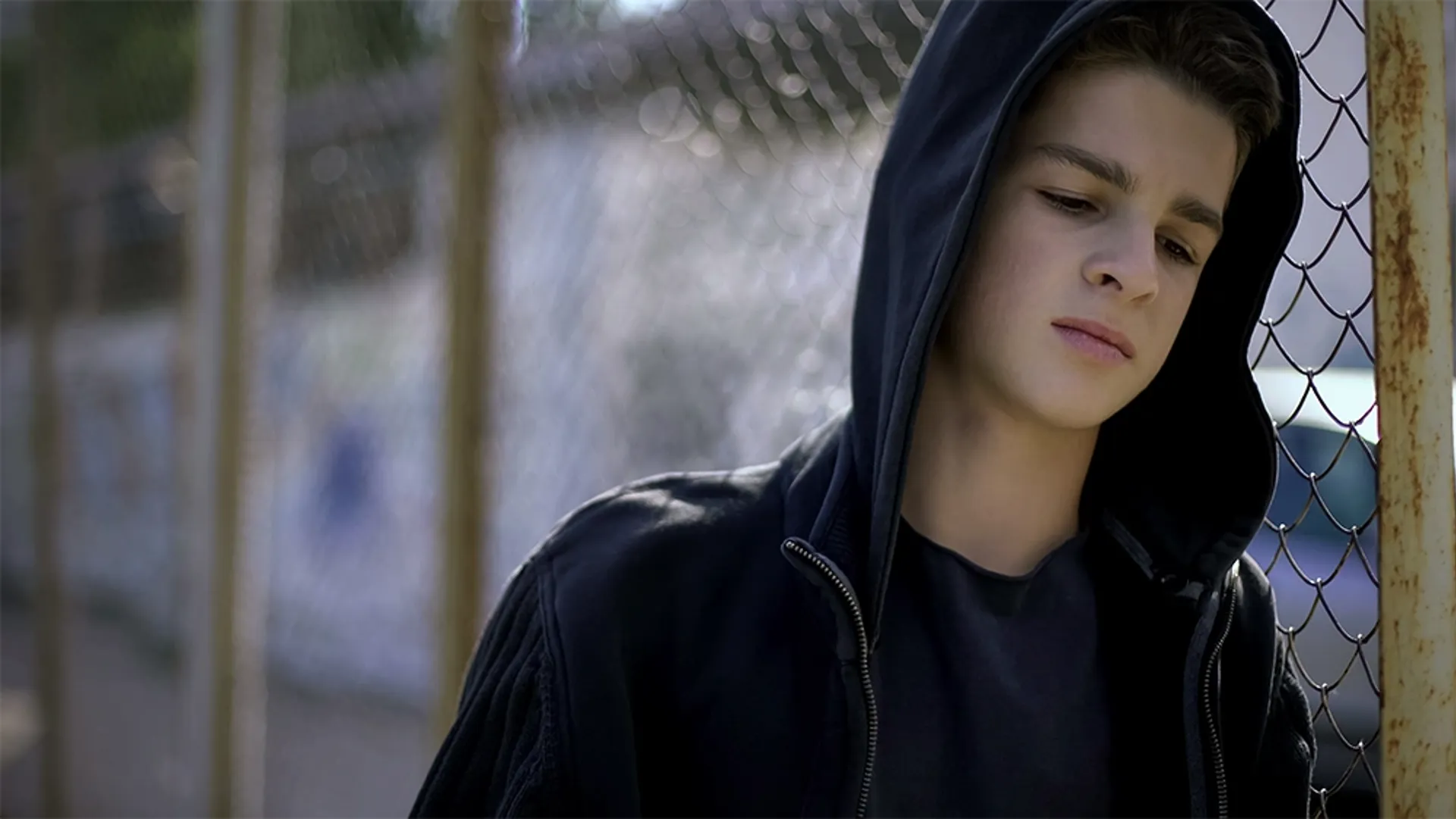Young male wearing hoodie, in detention