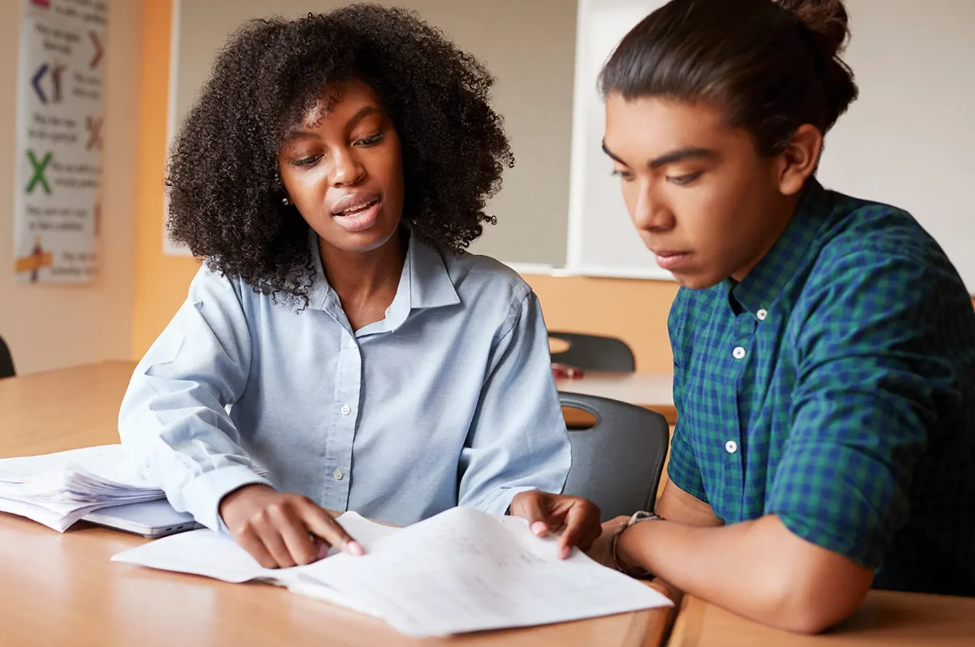 Counselor helping male juvenile in a classroom envirnoment