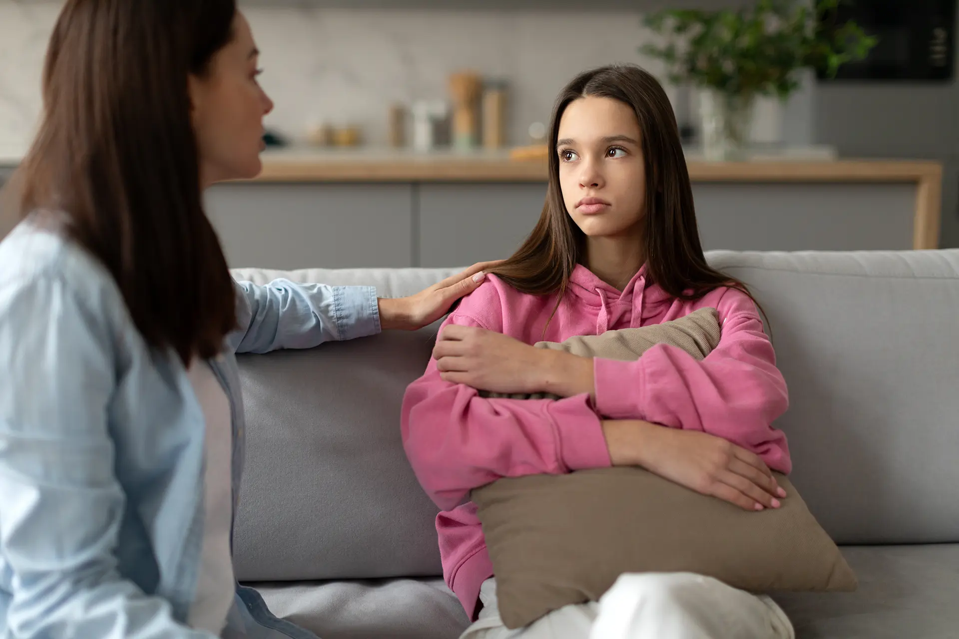 Mother consoling her depressed teen daughter