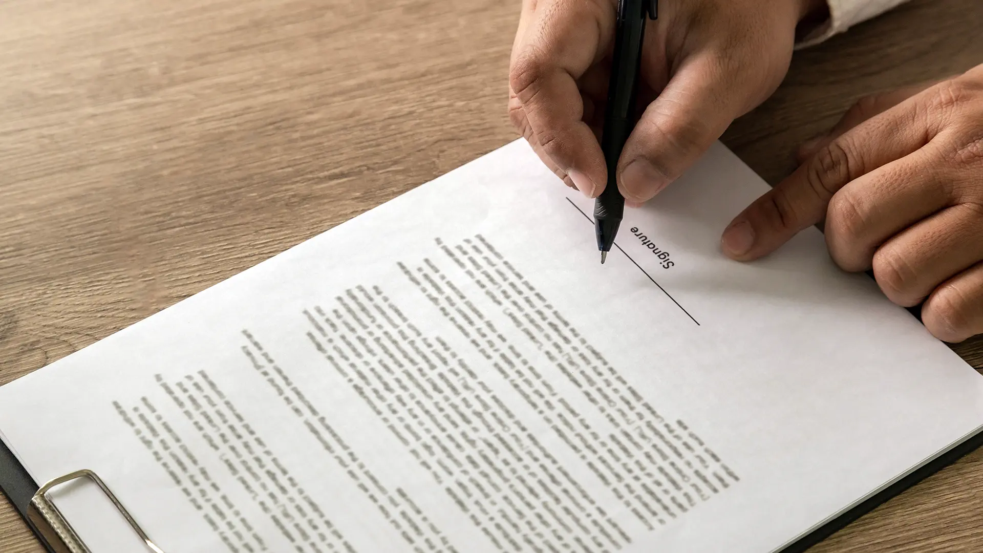 Closeup on someone's hands, signing a form