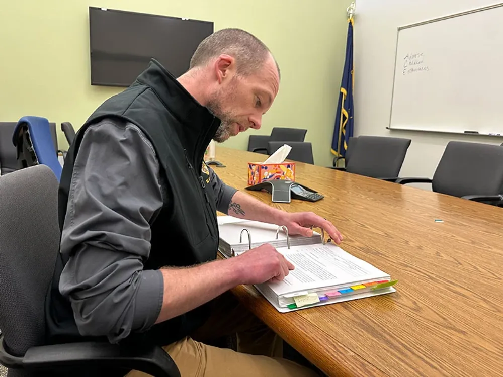 Juvenile Probation Officer, looking through binder in conference room