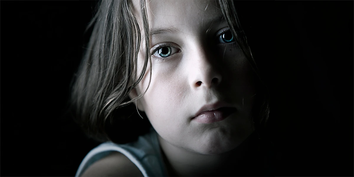 Sad child in a dark room