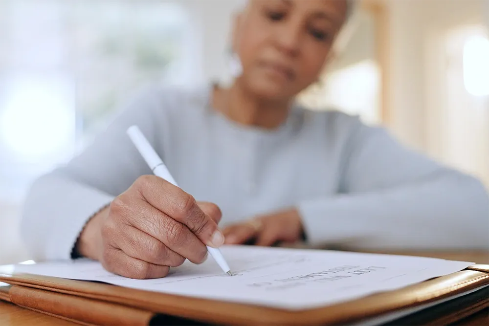Closeup on a woman's hand as she fills out paperwork