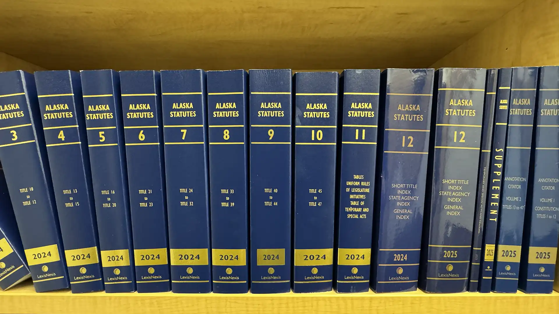 Volumes of Alaska Statutes on a bookshelf