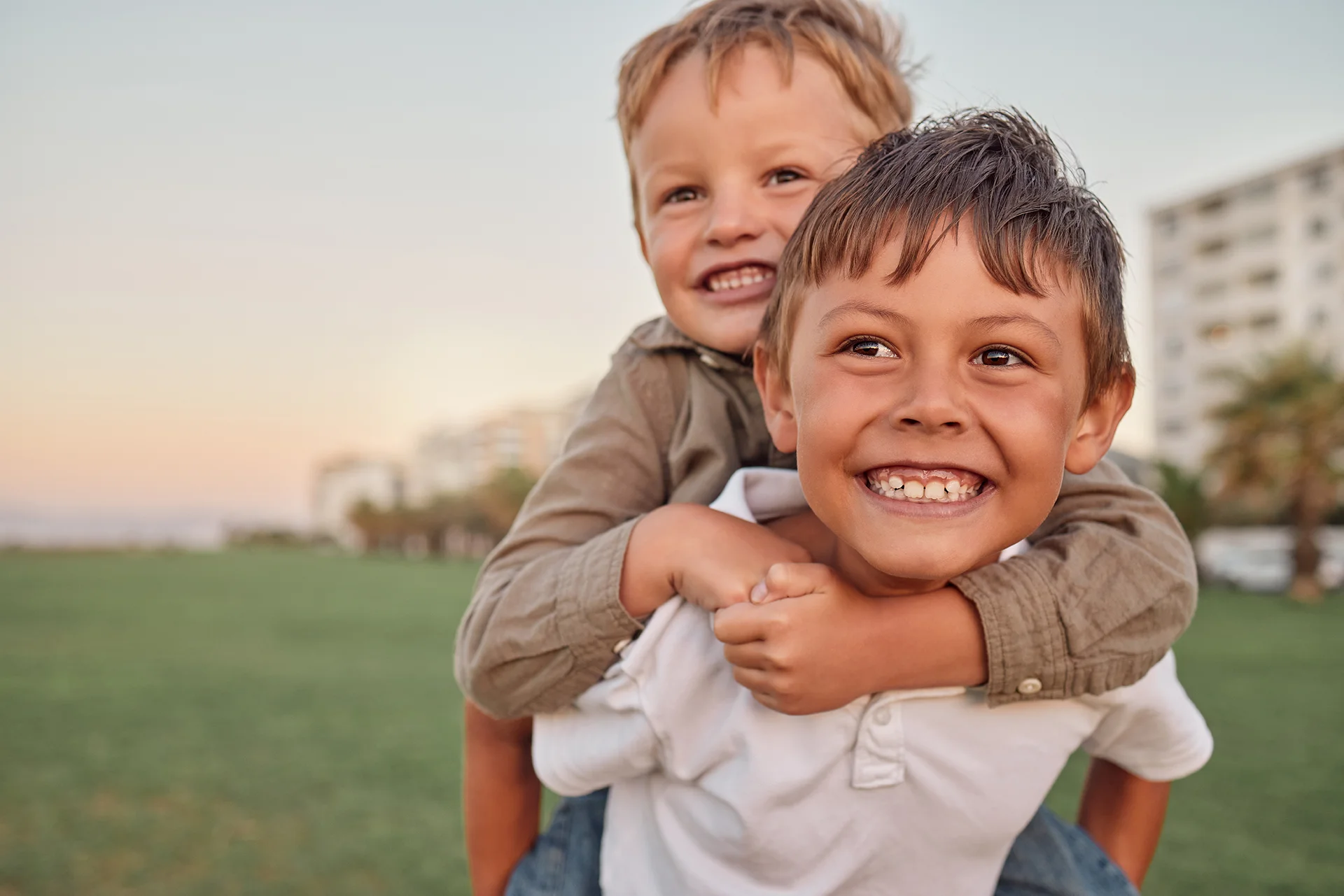 Happy brothers piggybacking in a park