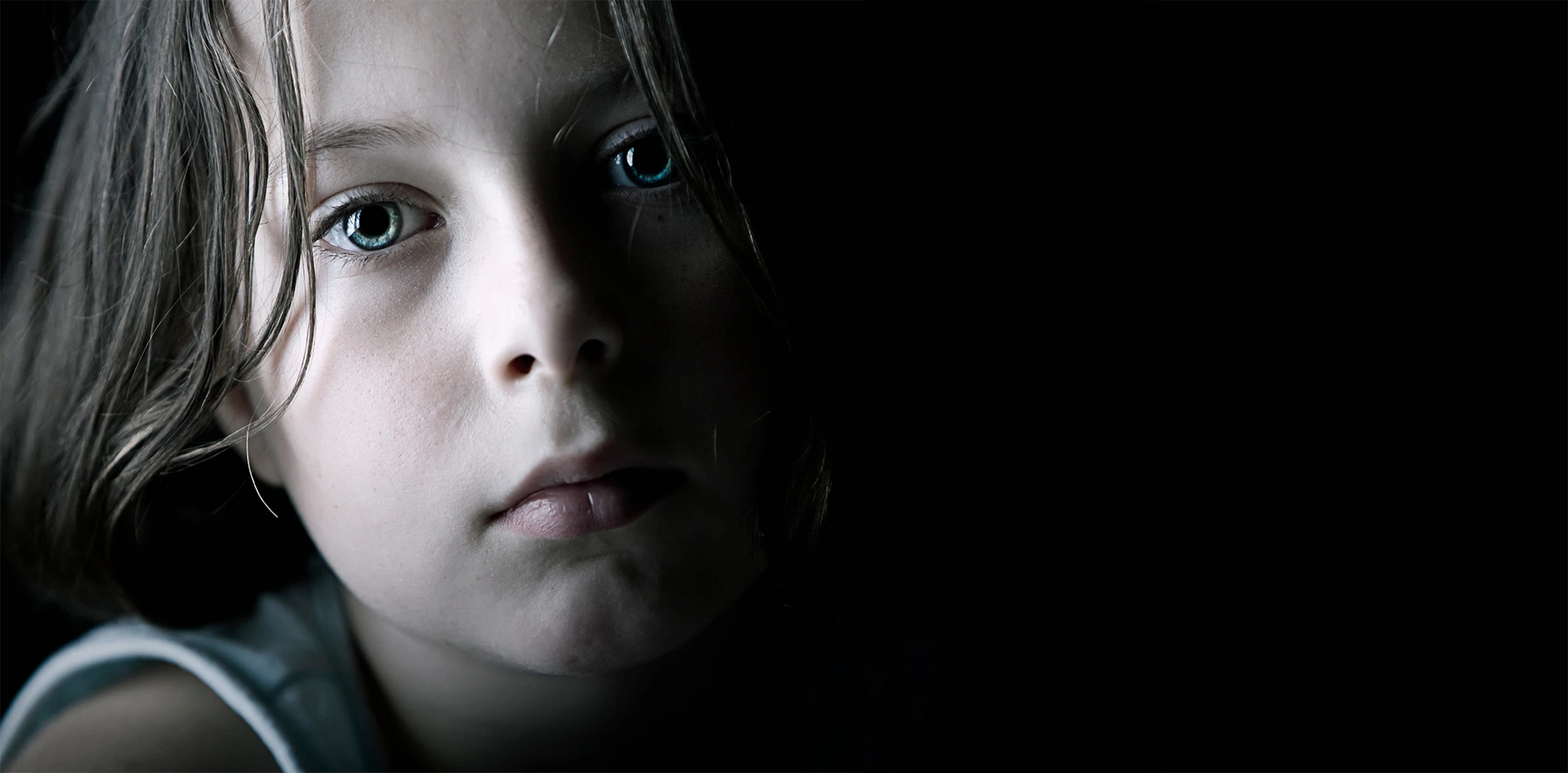 Sad child in a dark room