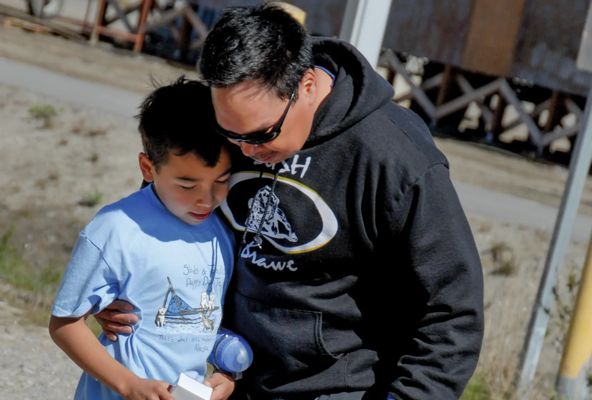 Native father hugging his son
