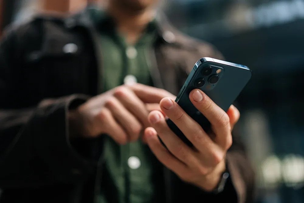 Close-up hands holding and using a smartphone