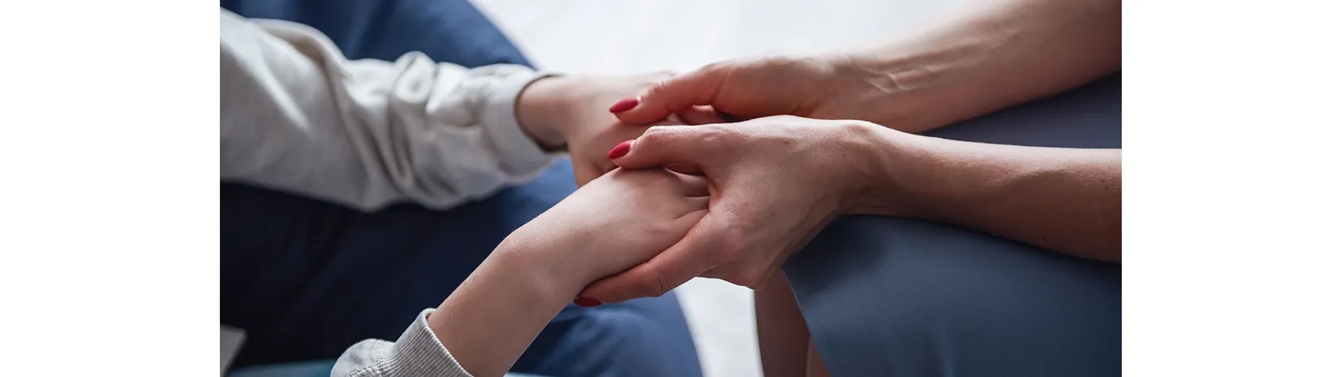 Older woman holding younger woman's hands