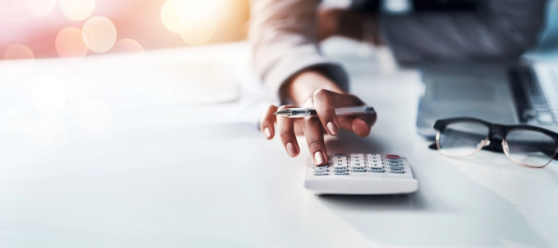 Woman using a calculator on a desk