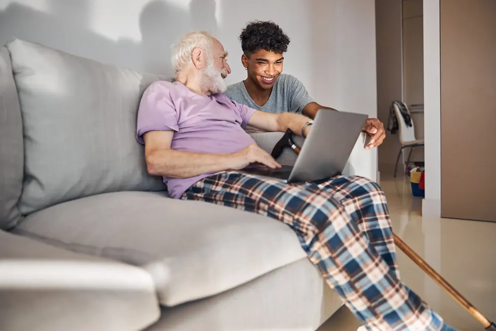 Young man helping elder with computer