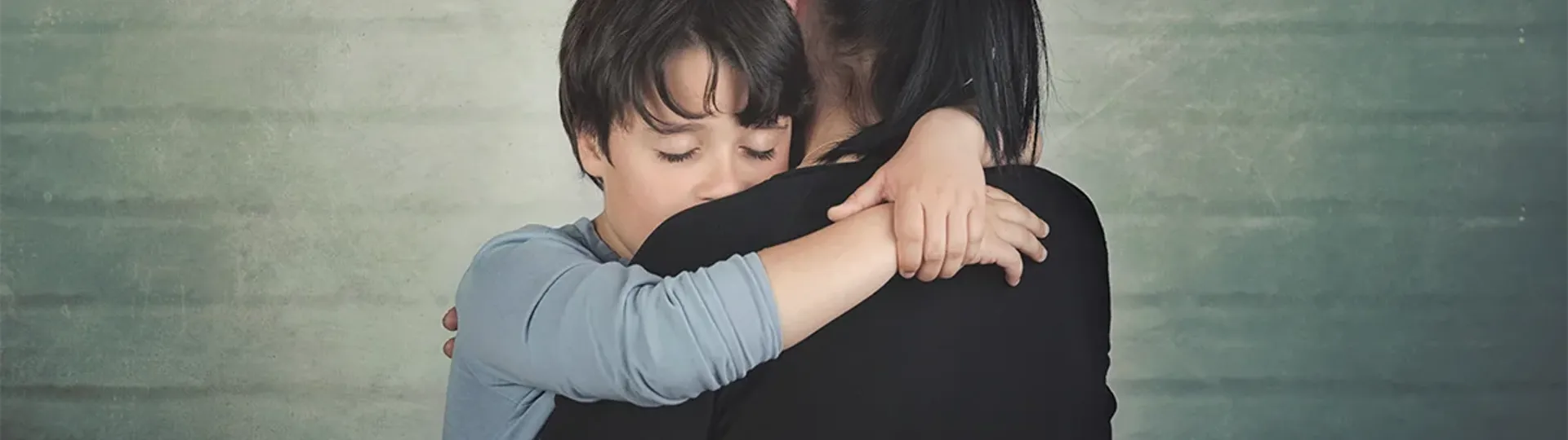 Child hugging woman with relief or sadness
