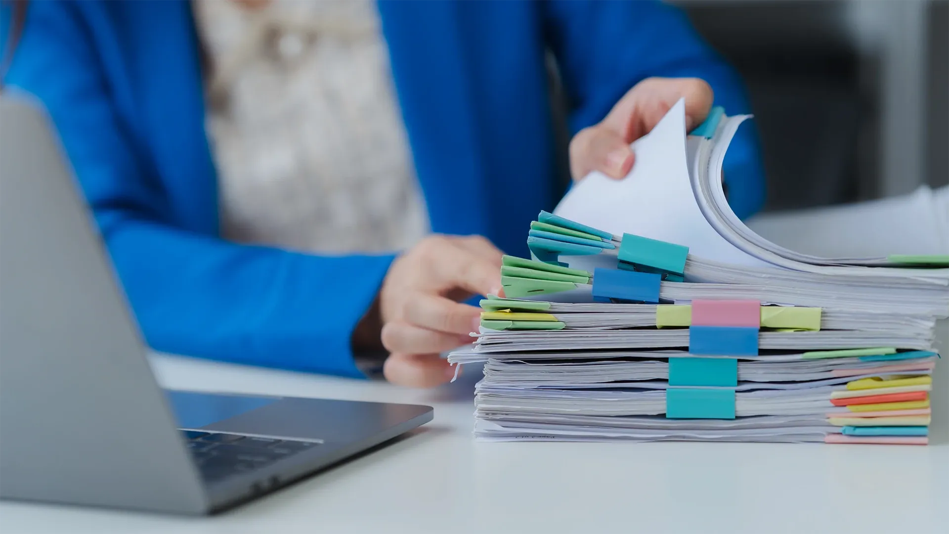 Woman sorting through a tall stack of tabbed papers
