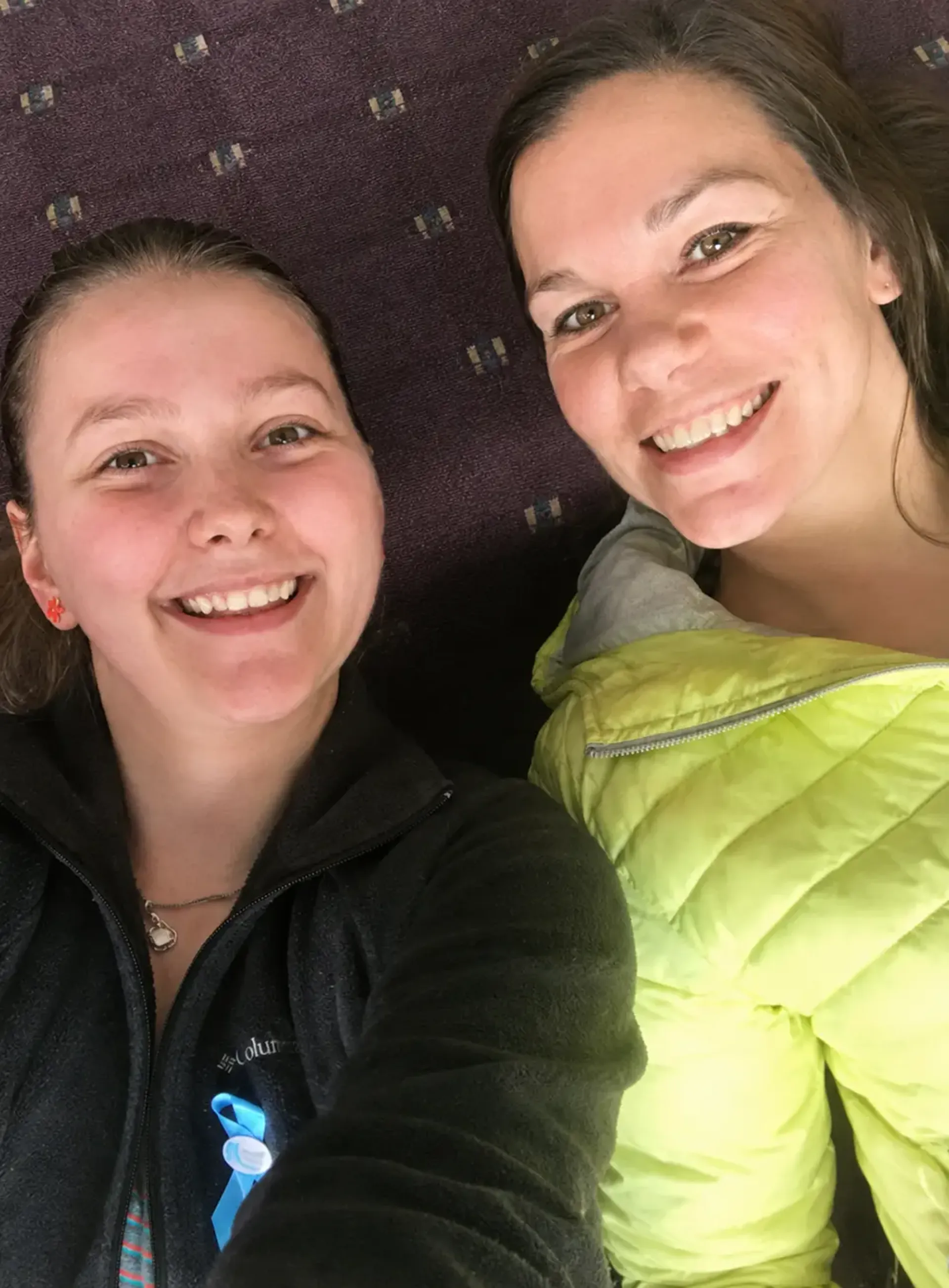 Two women laying on the the floor, taking a selfie