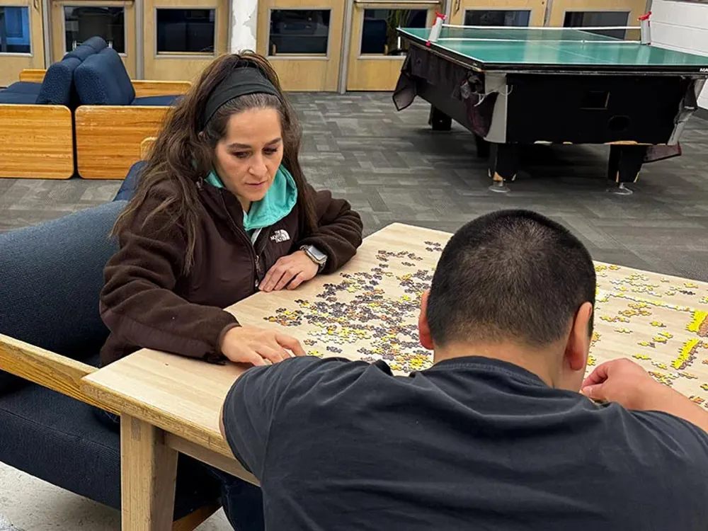 Juvenile Justice Counselor putting together puzzle with youth