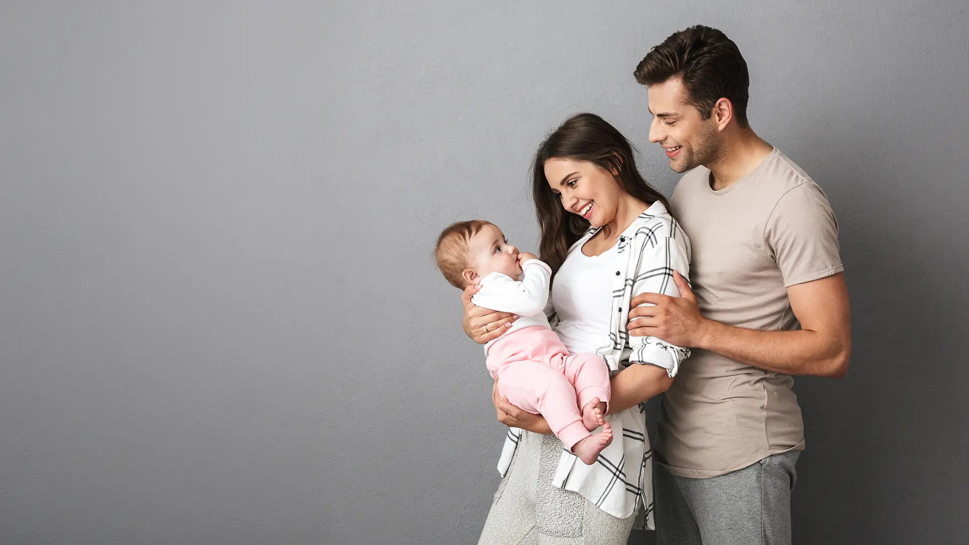 Couple holding and smiling at baby