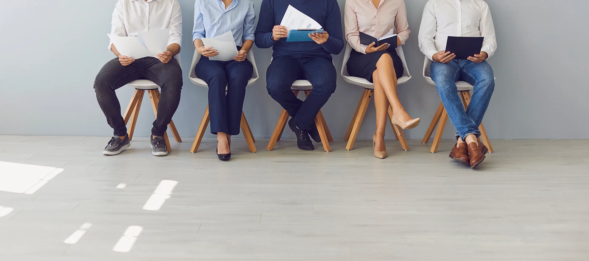 Five applicants sitting in chairs, heads obscurred