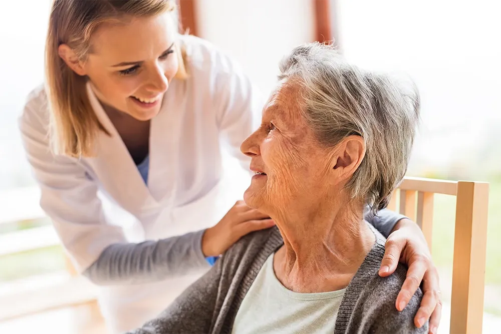 Health care worker comforting elder