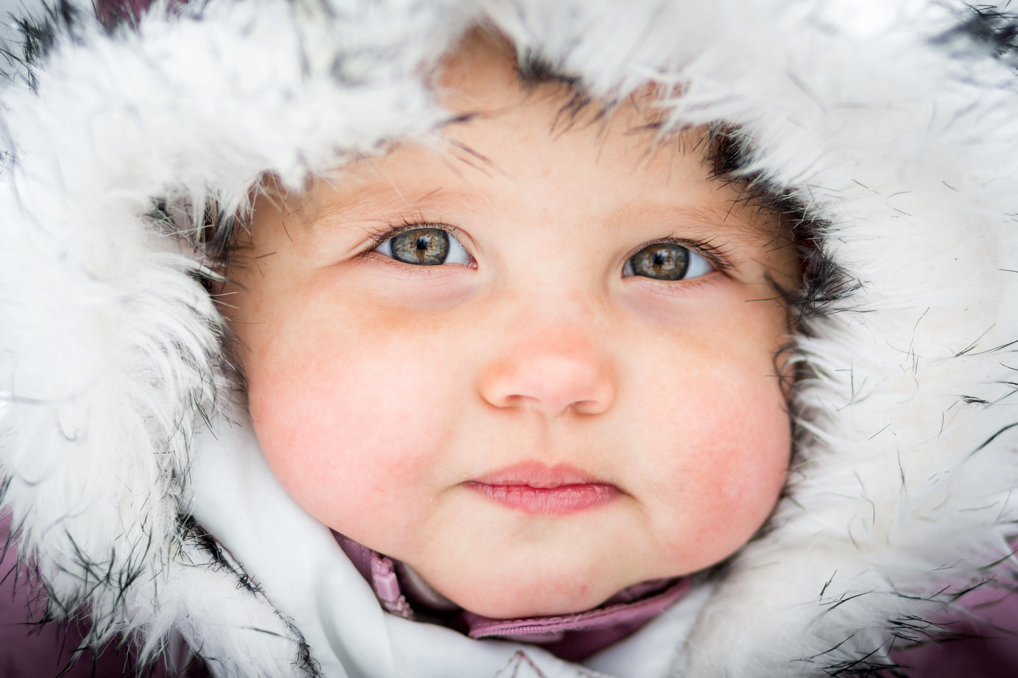 Baby face surrounded by fur hood