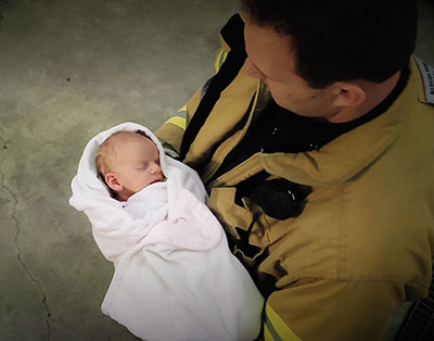 Fireman holding baby who has been surrendered